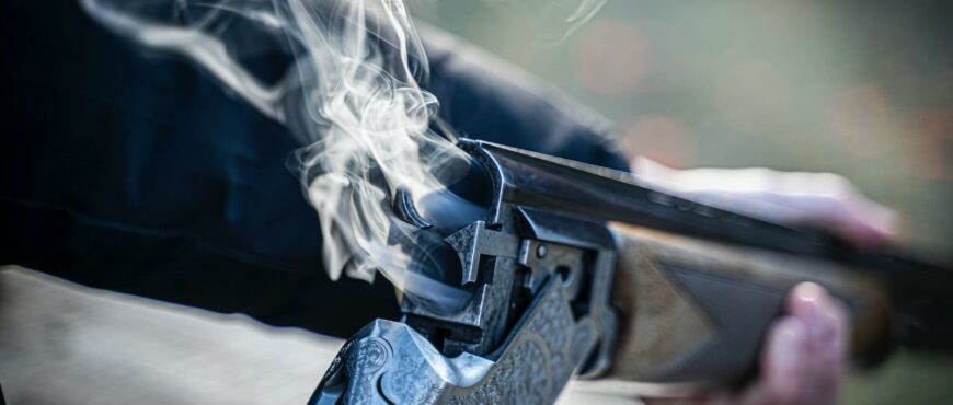 black semi automatic pistol with white smoke